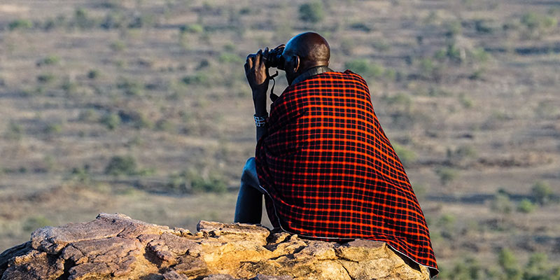 A man sitting on a rock looking into the distance